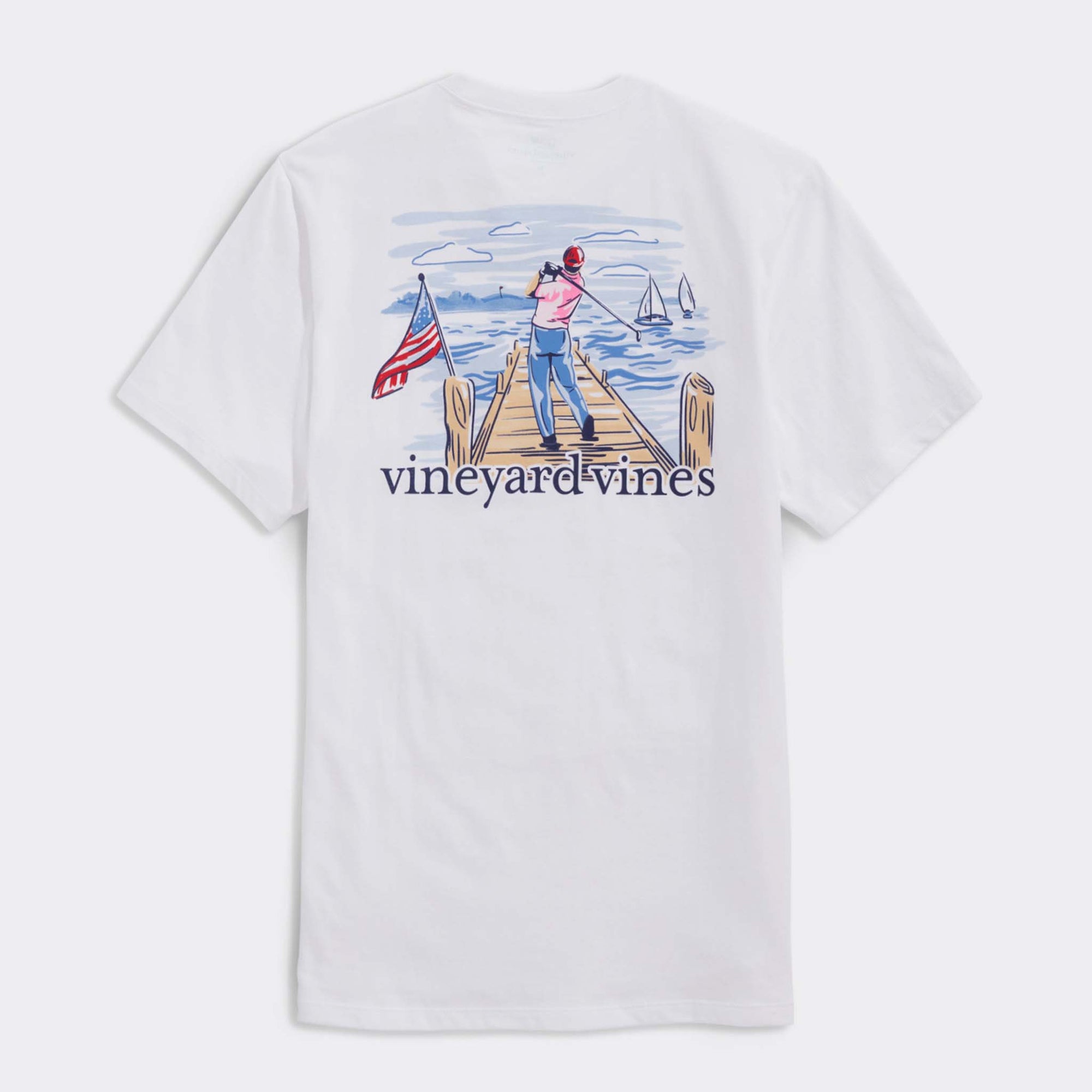 White t-shirt with a graphic of a person fishing on a dock and an American flag, branded 'Vineyard Vines'.
