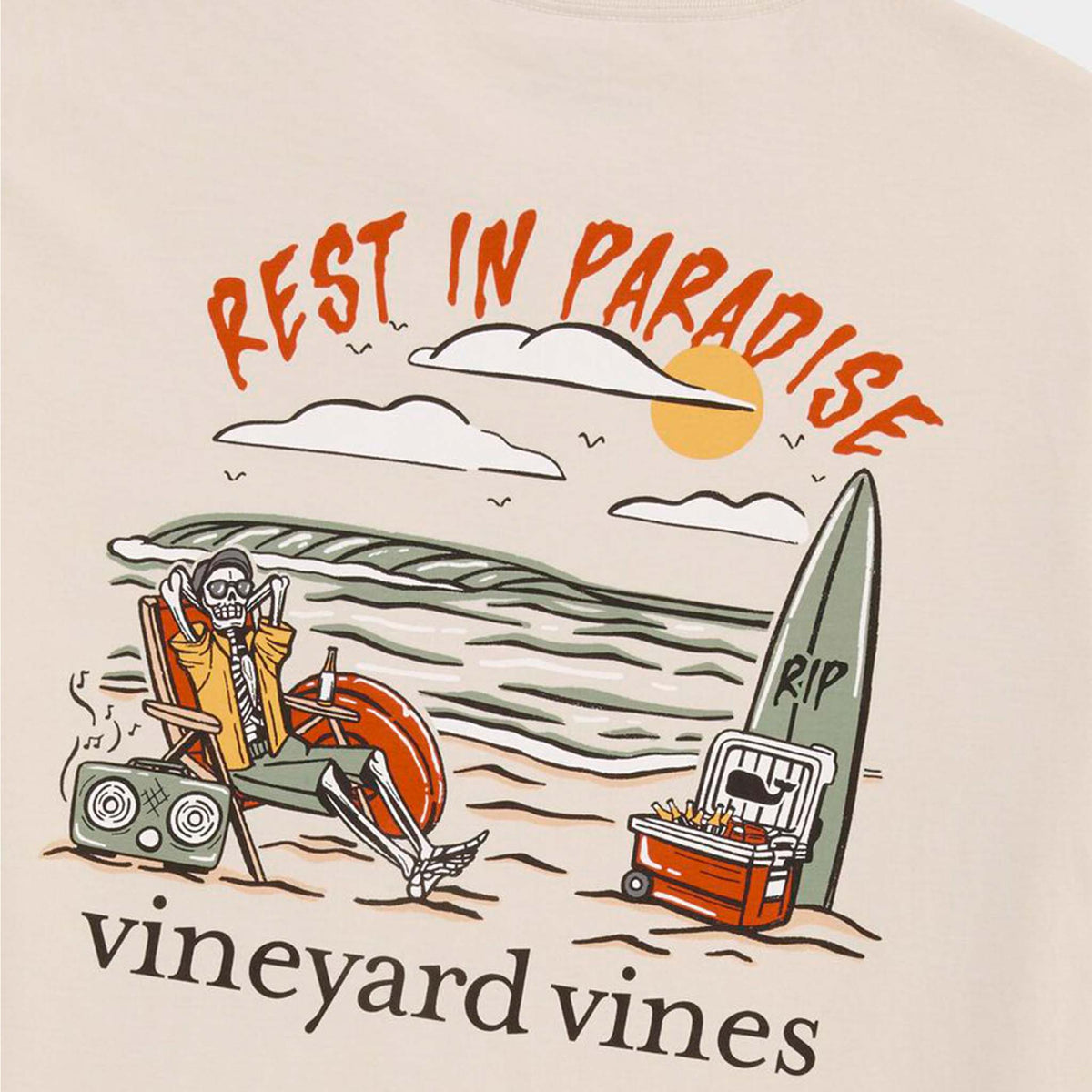 Close-up of back graphic showing skeleton on beach chair with drink, cooler, surfboard, and orange sunset with “Rest in Paradise” text.