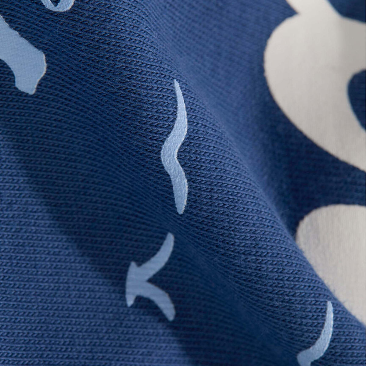 Close-up of blue fabric with white bird patterns