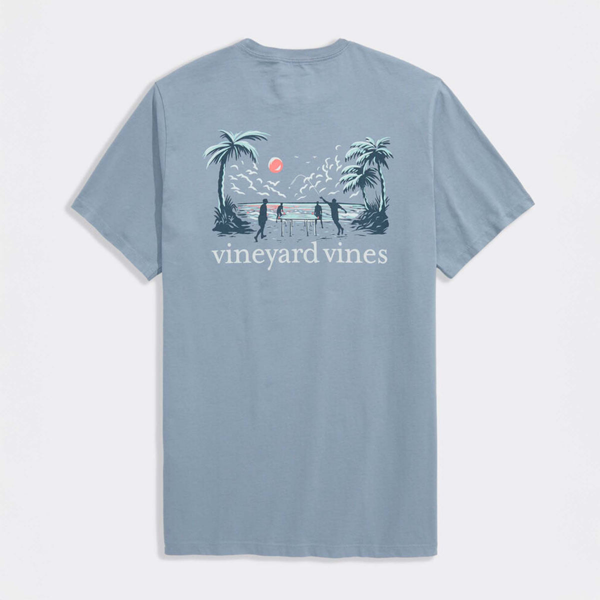 Back view of light blue Vineyard Vines t-shirt featuring beach scene graphic with palm trees, ocean sunset, and players around a table.