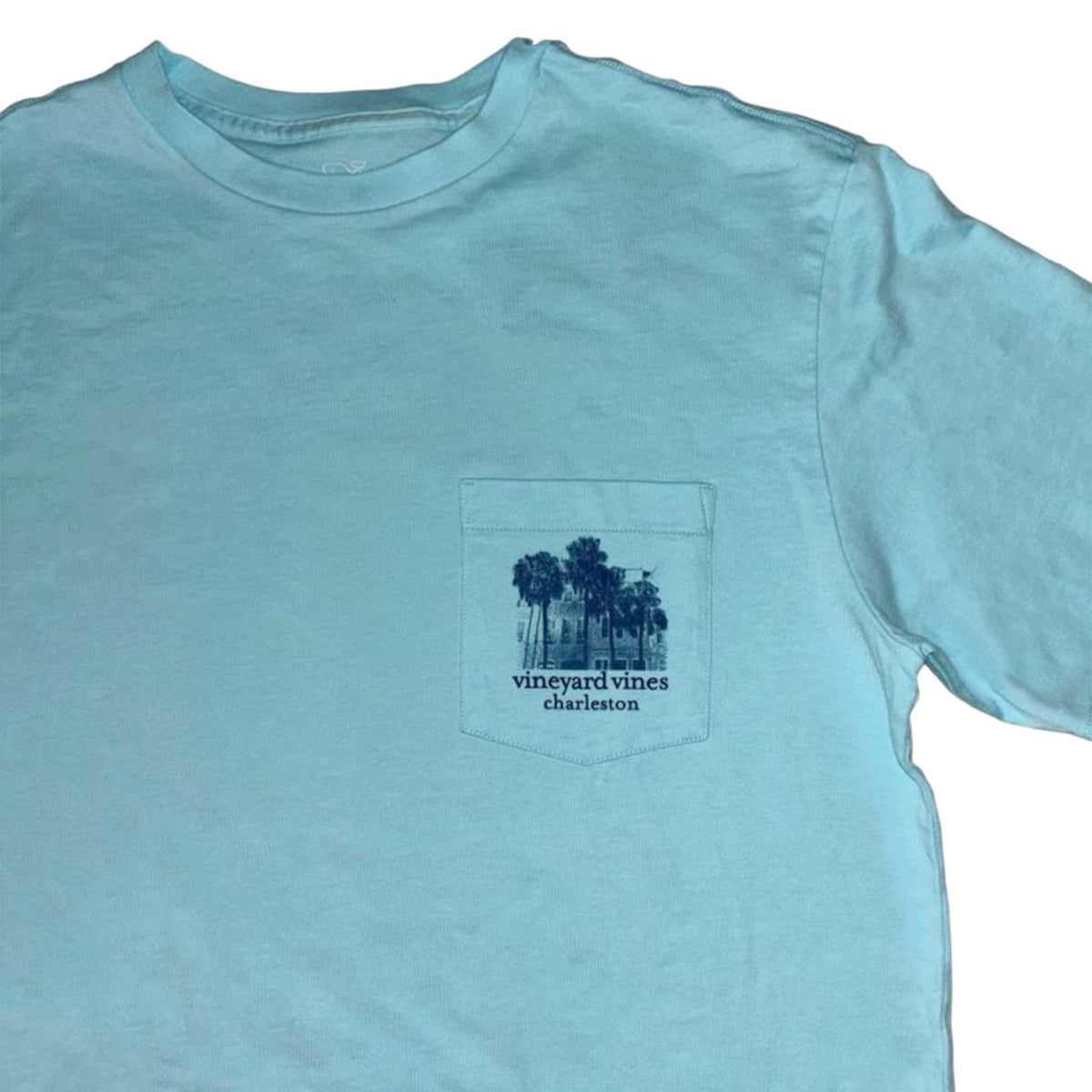 Light blue t-shirt with palm tree design and 'vineyard vines Charleston' text on a white background