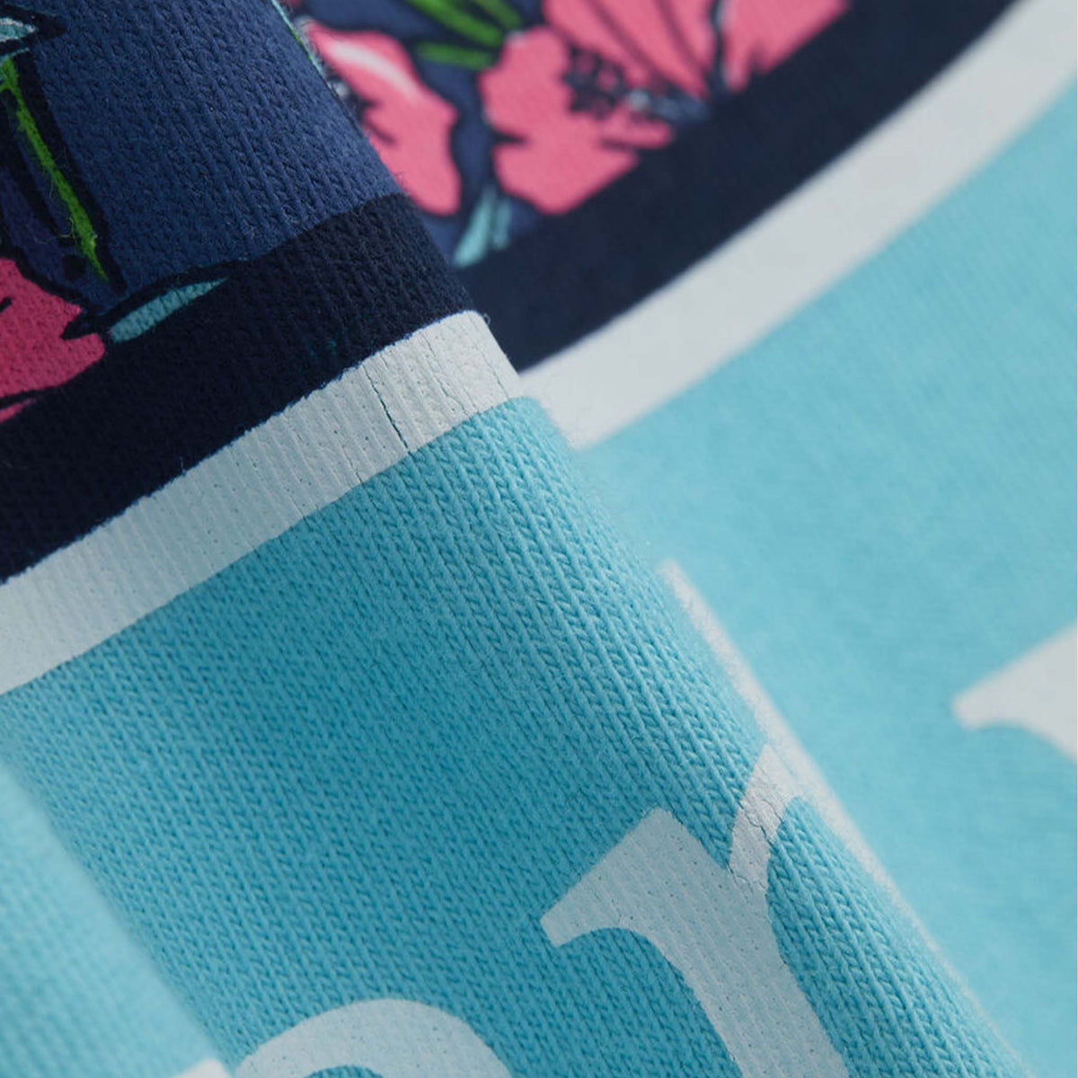 Vineyard Vines Short Sleeve Pocket T-Shirt in Turquoise fabric close-up highlighting printed whale design texture on soft cotton material.