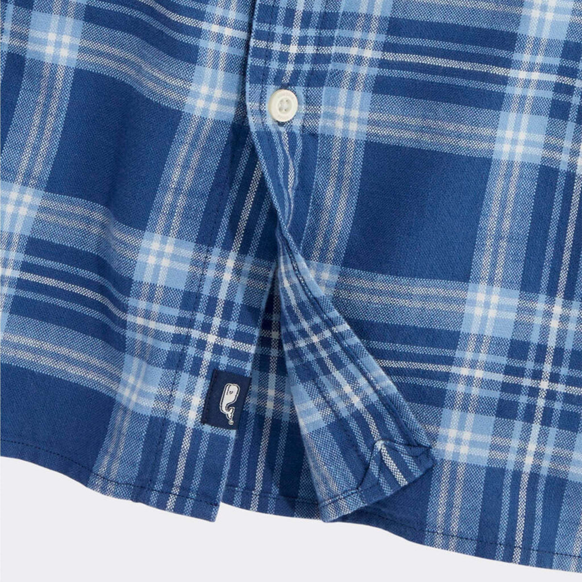 Bottom hem of blue plaid button-down shirt with Vineyard Vines whale logo tag.