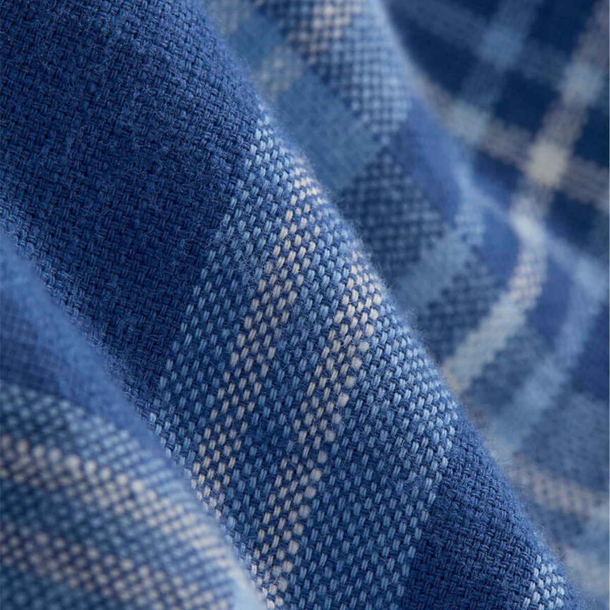 Close-up of blue and white plaid fabric texture showing detailed weave.