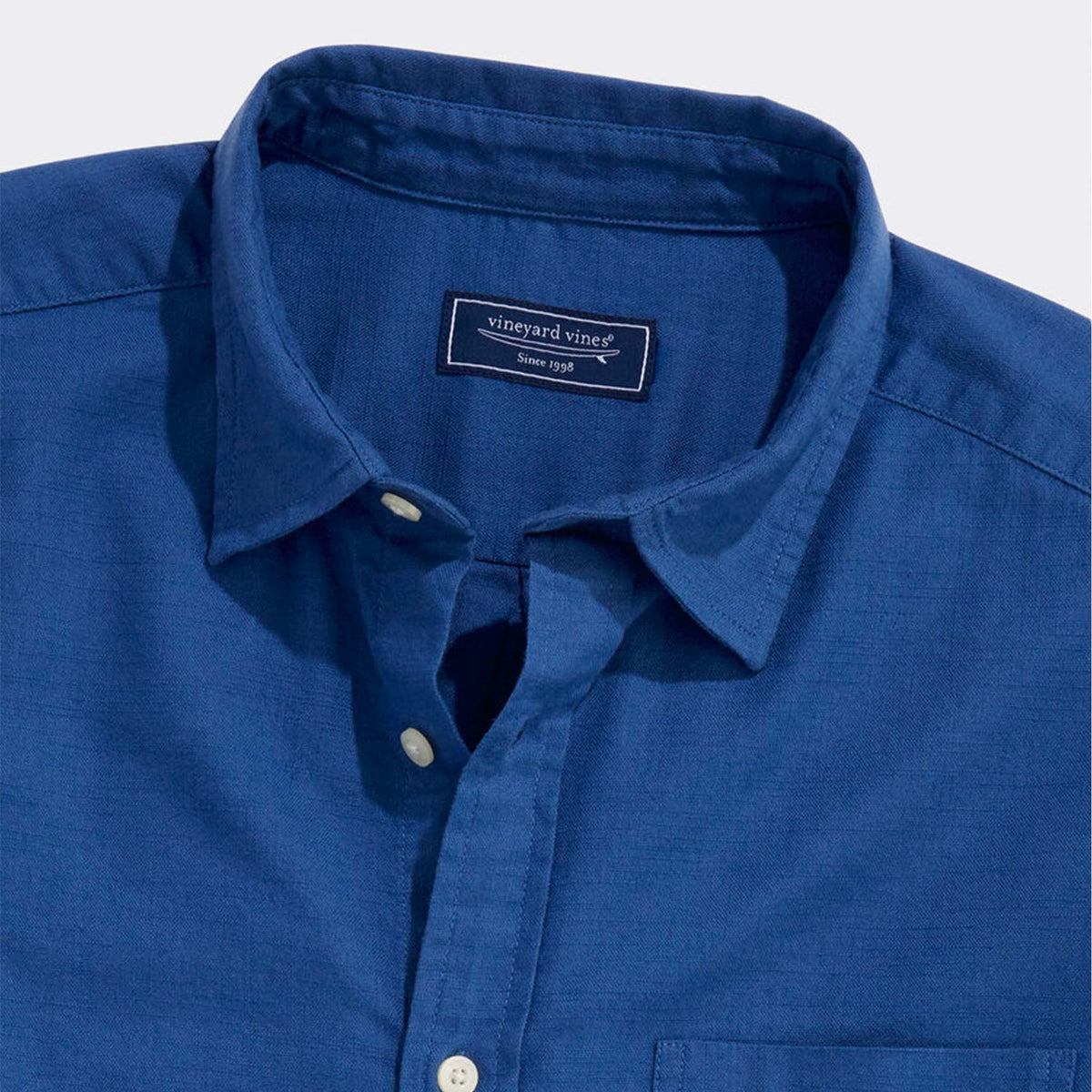 Collar and button placket detail of Vineyard Vines solid Moonshine blue button-down shirt.