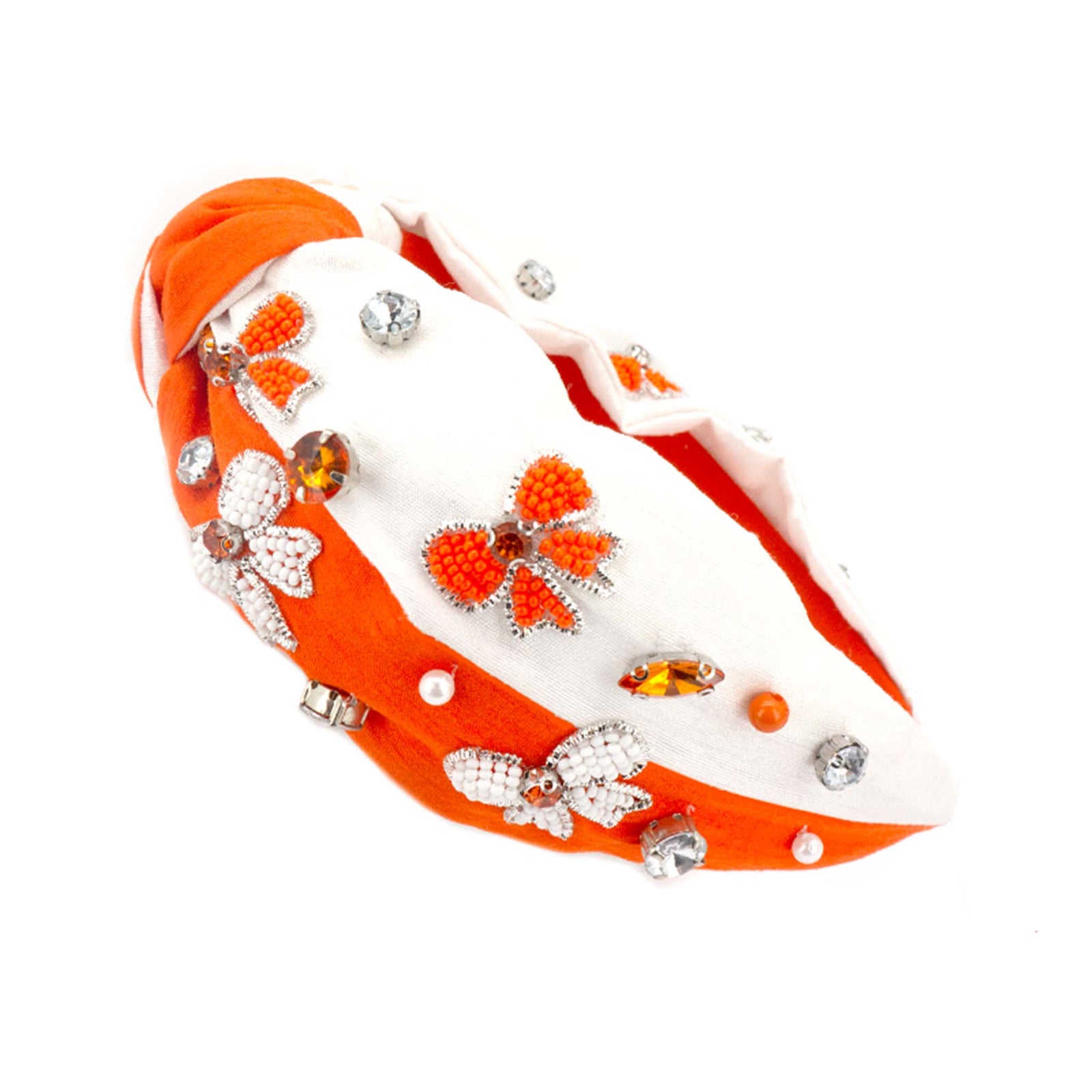 Orange and white knotted headband embellished with beaded bow designs, pearls, and rhinestone accents.