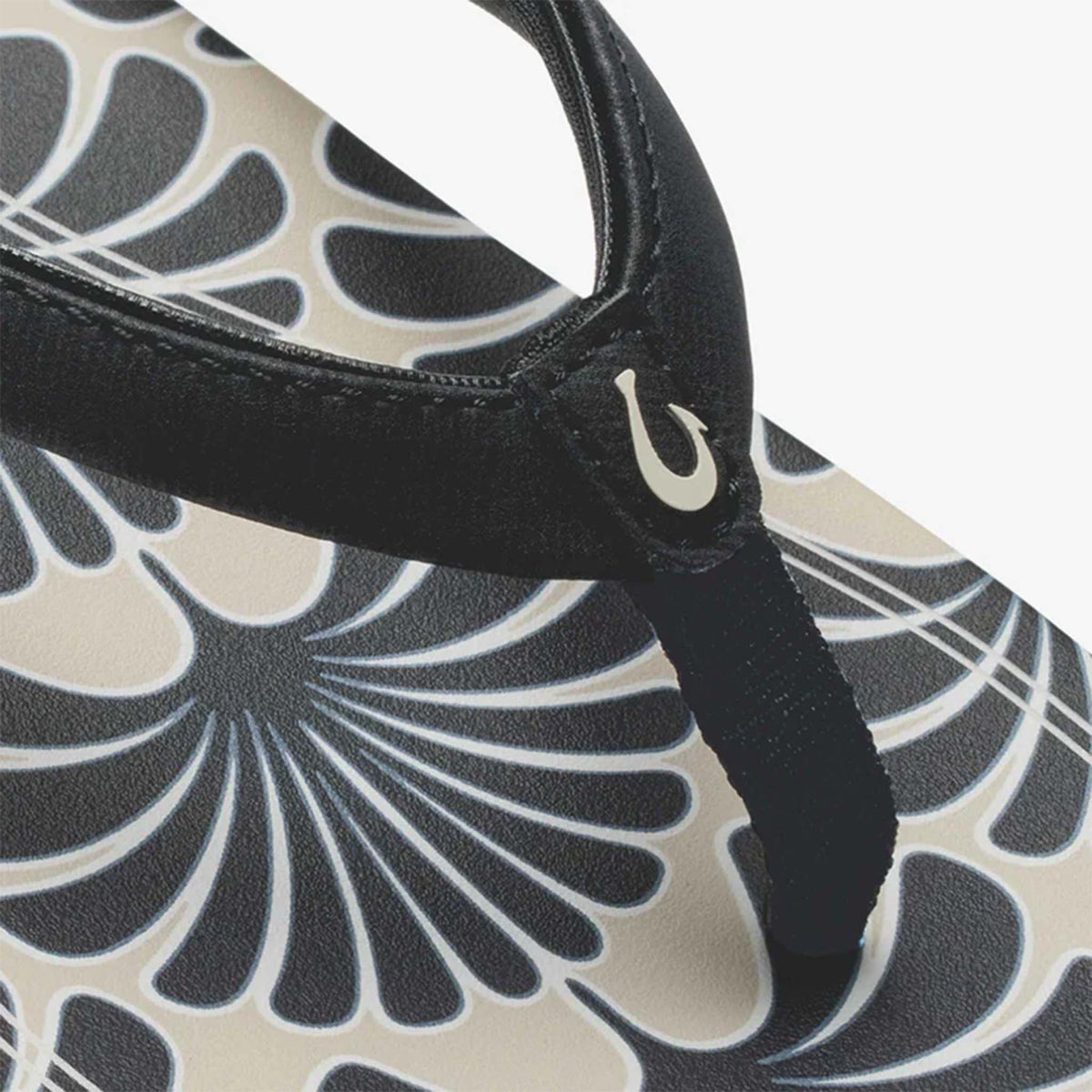 Black and beige floral Olukai sandal shown on a white background.