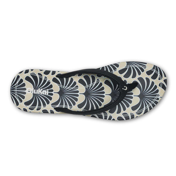 Black and beige floral Olukai sandal shown on a white background.