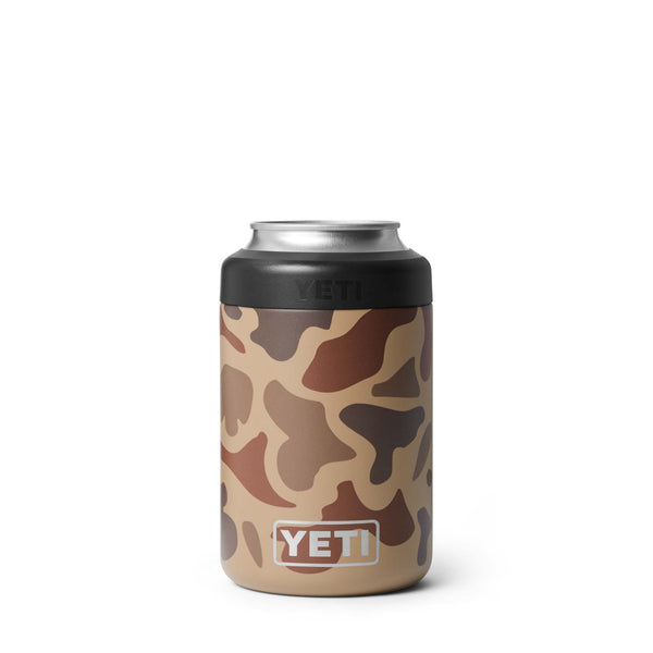 Front view of YETI Colster in Wetlands Camo showing stainless YETI logo at bottom over multicolor camo background and black ring securing the can.