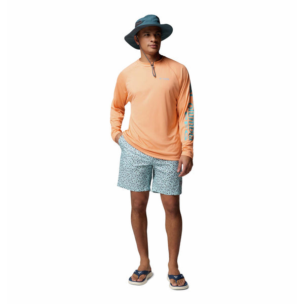  Man wearing an orange long-sleeve shirt and patterned shorts on a white background