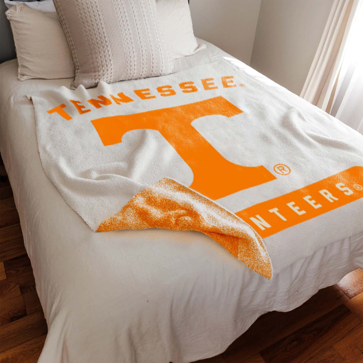 Blanket with Tennessee Volunteers logo draped over a bed