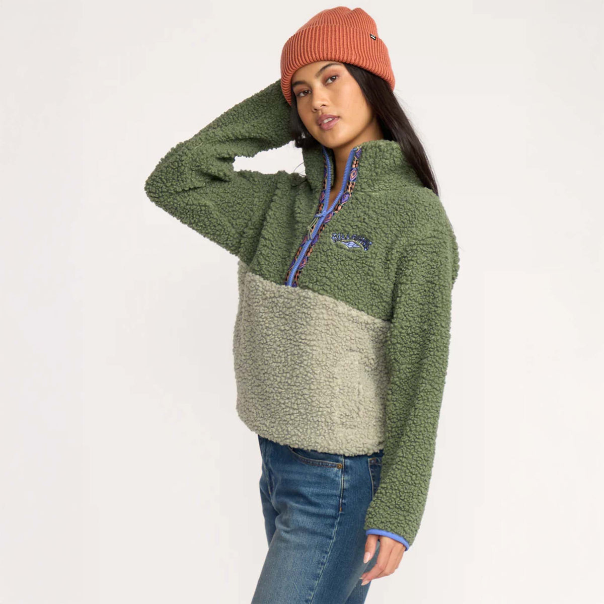 Side view of woman wearing two-tone green sherpa pullover, showing relaxed fit and soft textured fabric.