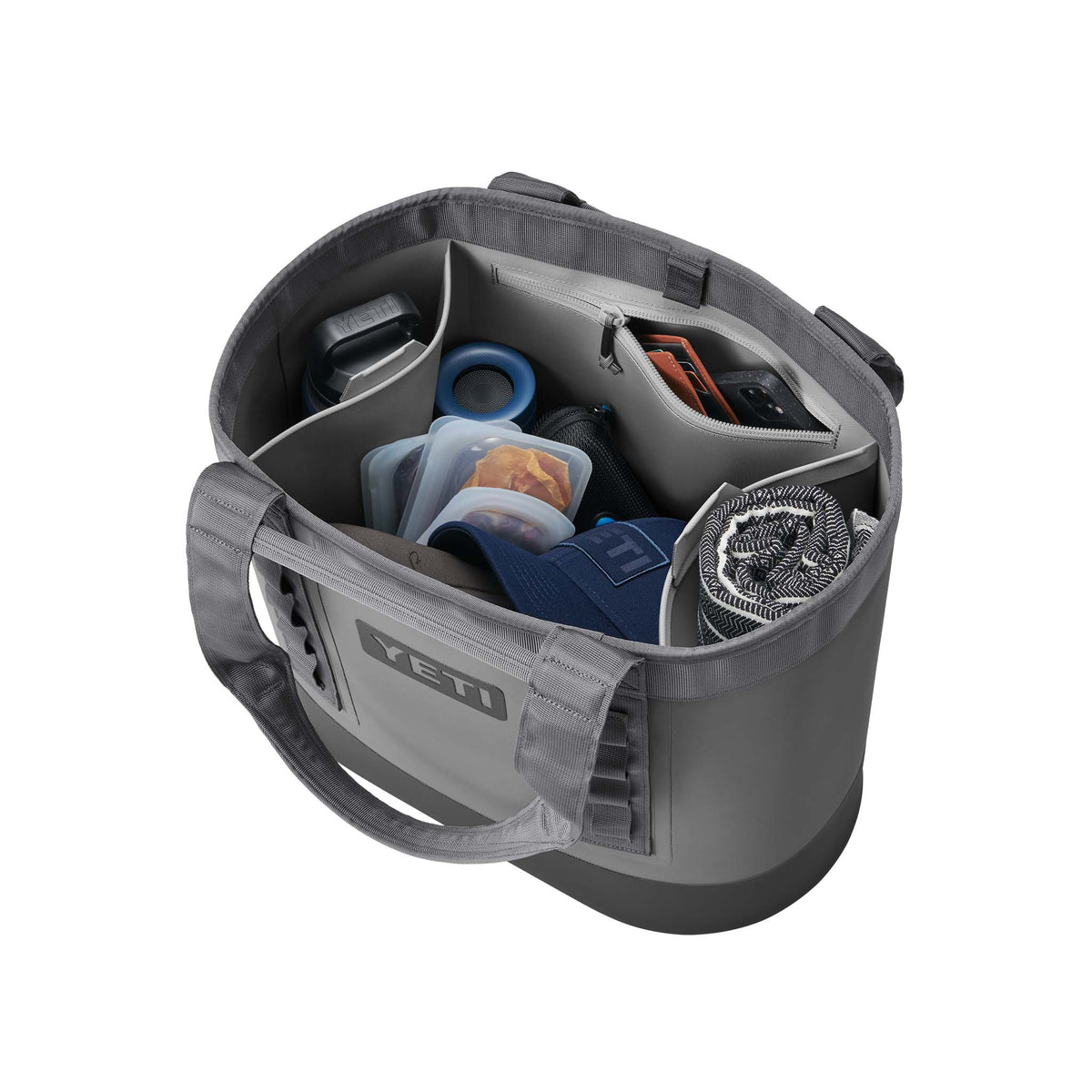 YETI Camino 35 Carryall in Storm Gray shown filled with items including a water bottle, hat, containers, and towel inside divided compartments.