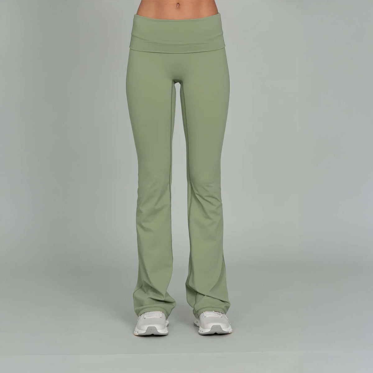 Front view of Gold Hinge light green fold over flare leggings paired with sneakers