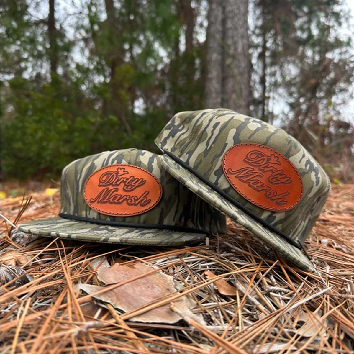 bottomland camo hat with an oval leather patch featuring dirty marsh outfitters logo on the crown.