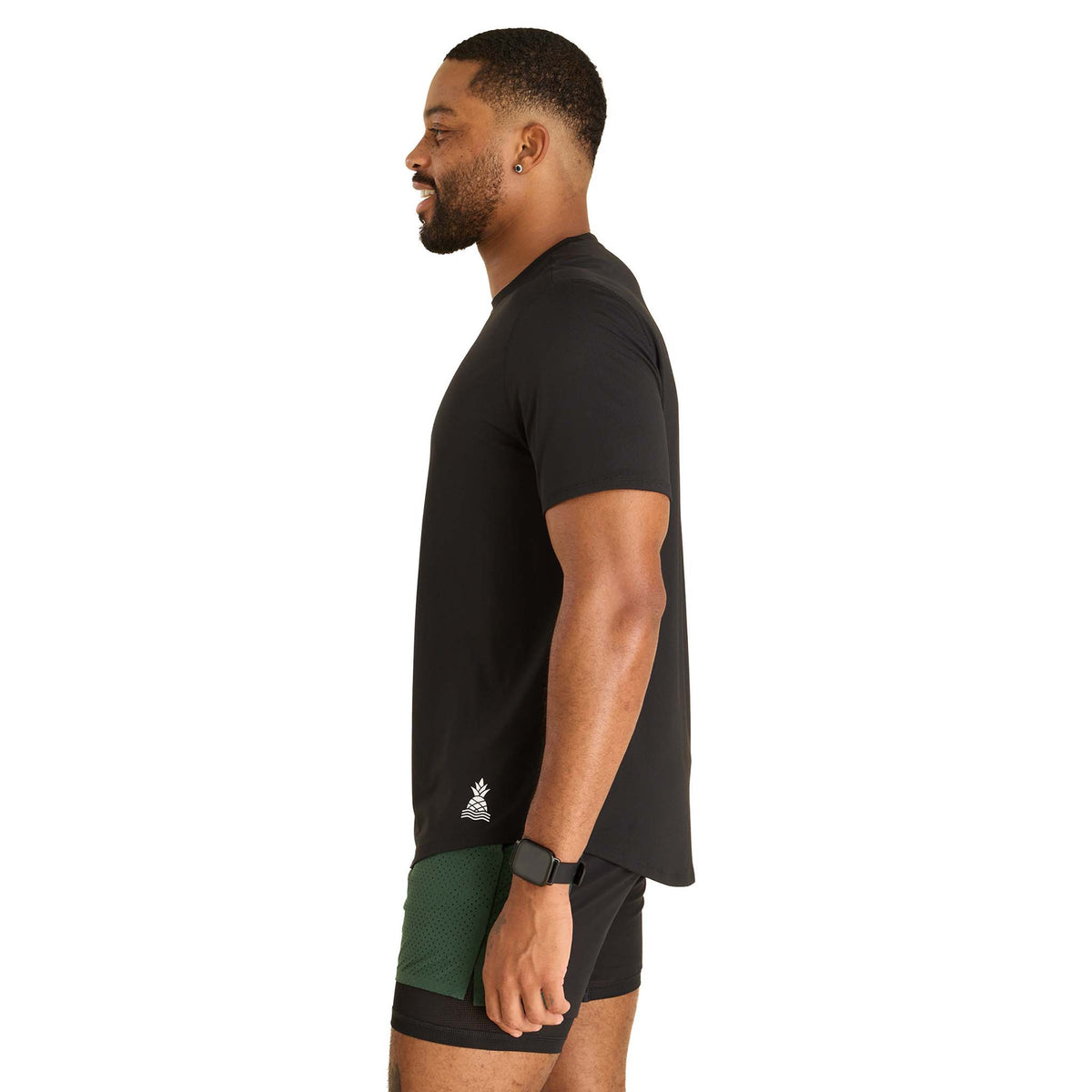 Man wearing a black t-shirt and green shorts on a white background