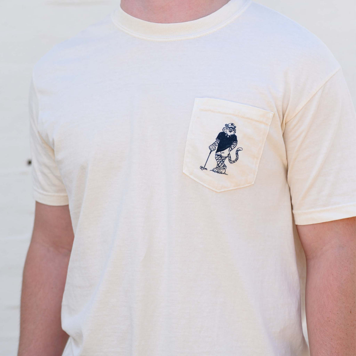 Ivory Auburn University t-shirt with Aubie golf graphic on pocket.