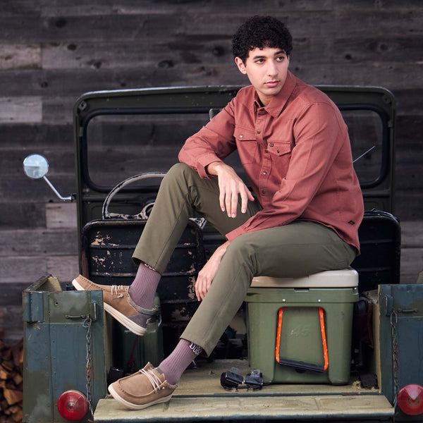 Person sitting on a vintage vehicle with a rustic background