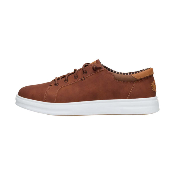 Side profile of Hey Dude Men's Paul Pro Classic Shoes in Cognac with white outsole and contrast stitching.