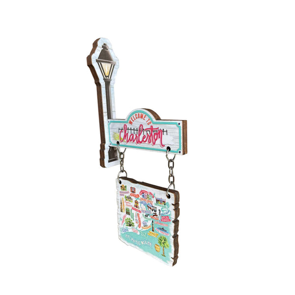 Charleston hanging wooden magnet with illustrated map and “Welcome to Charleston” sign, shown angled to highlight the layered design and chain detail.