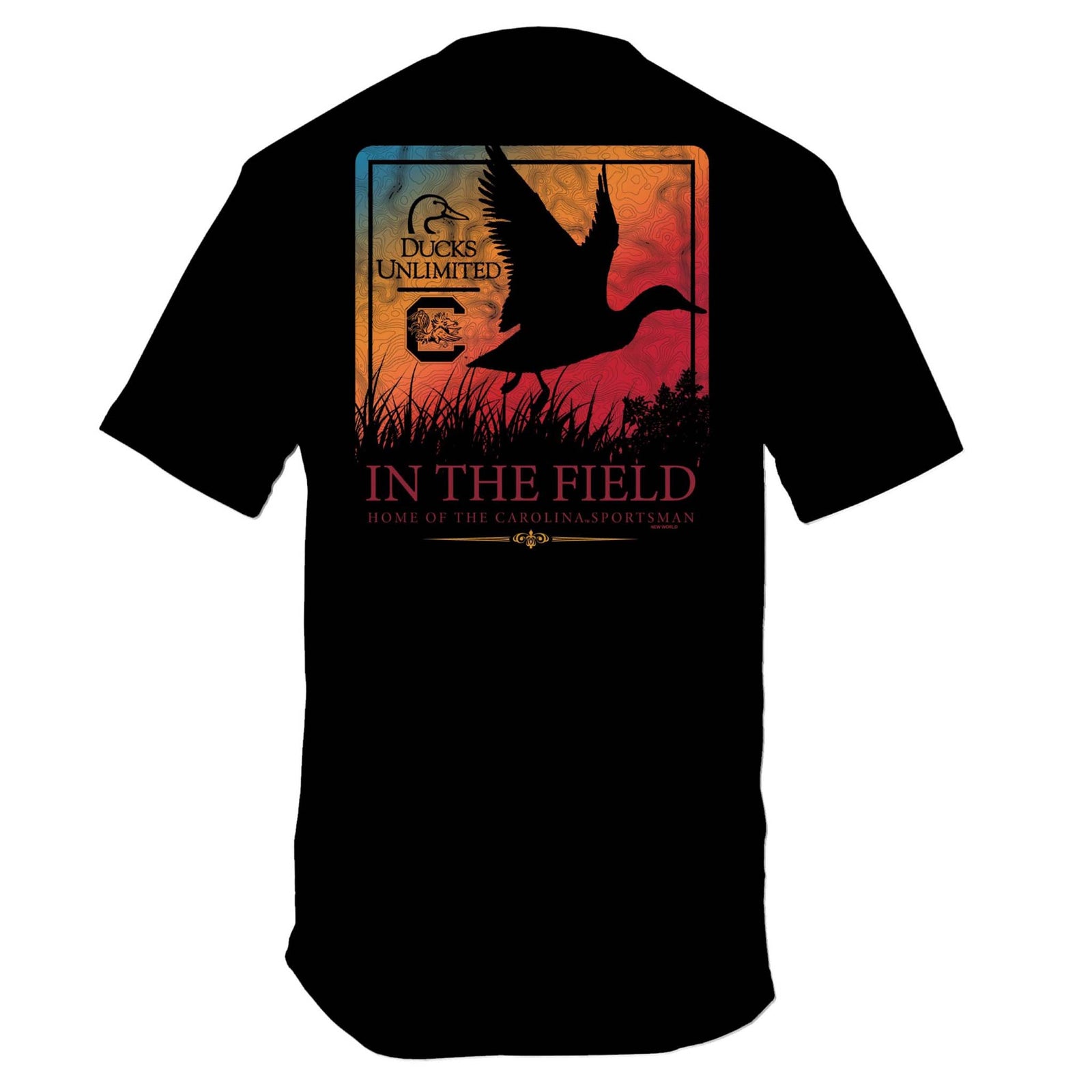 Back of black short sleeve t-shirt with large graphic of a duck silhouette flying over marsh grass in front of a sunset gradient background, text reading “In the Field – Home of the Carolina Sportsman” with Ducks Unlimited and South Carolina logo.