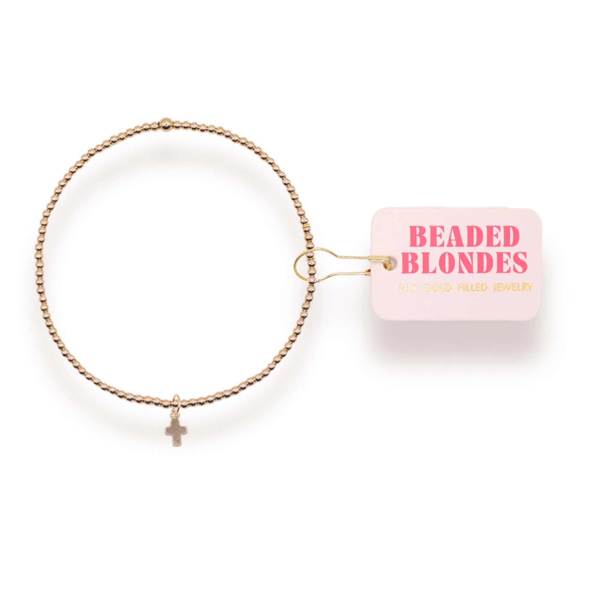 Gold bracelet with a small cross charm on a white background, featuring 'Beaded Blondes' packaging.