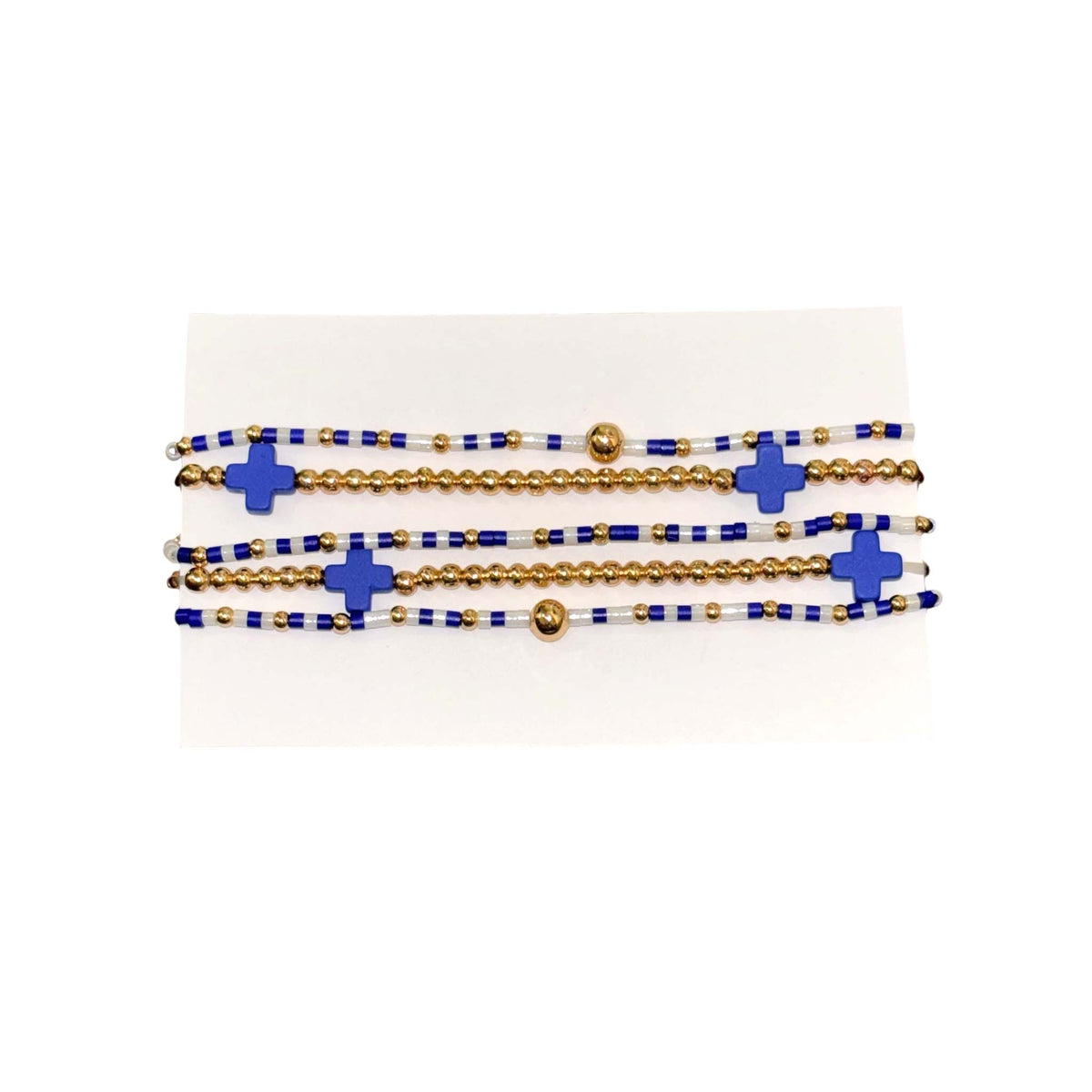 Set of blue and white beaded bracelets with gold accents and blue cross-shaped beads, designed for stacking or individual wear.