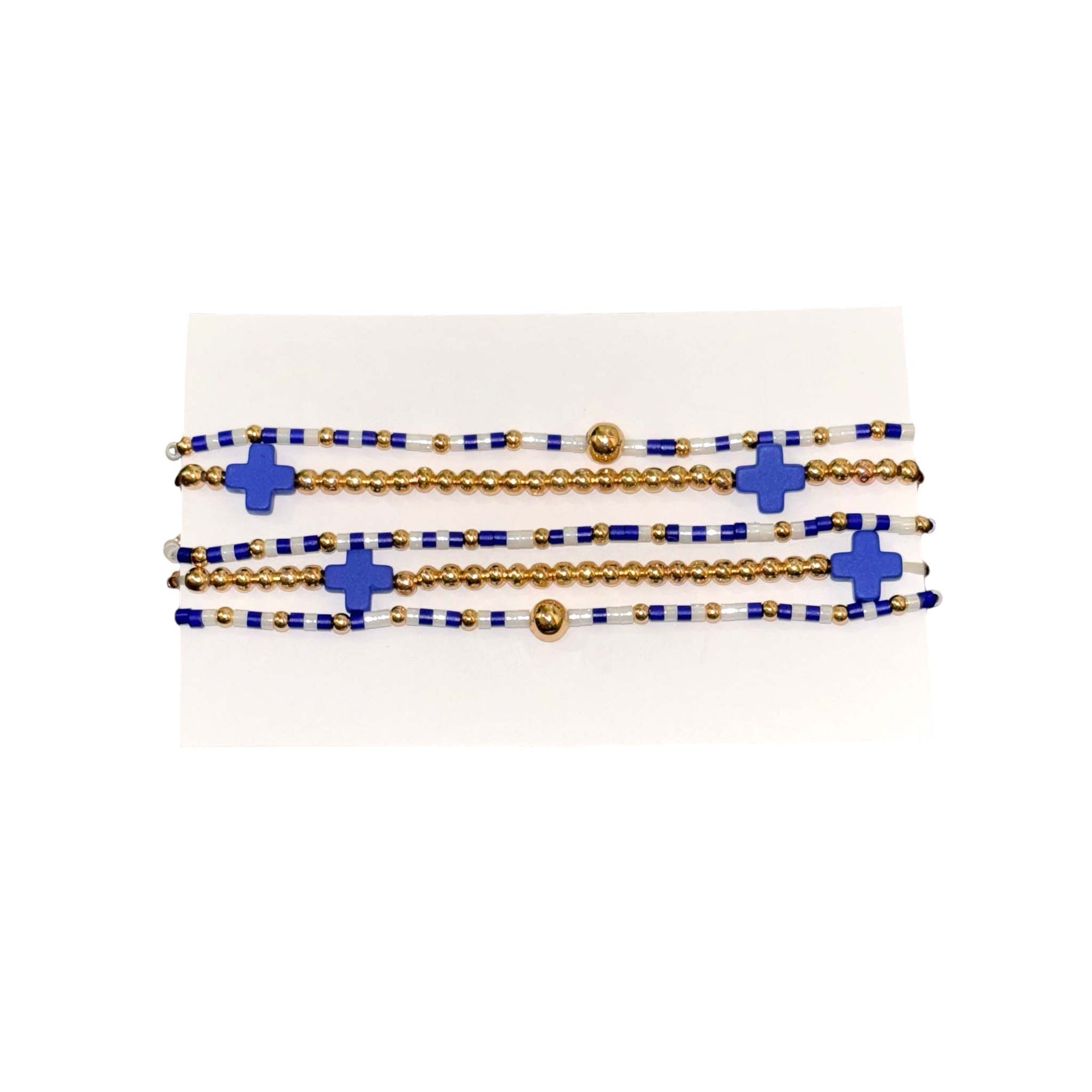 Set of blue and white beaded bracelets with gold accents and blue cross-shaped beads, designed for stacking or individual wear.