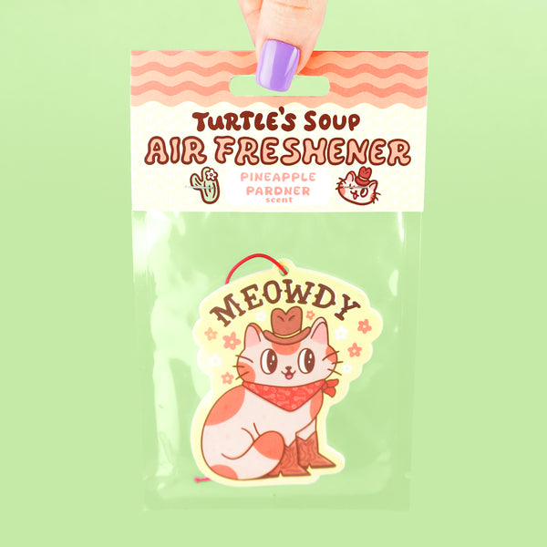 Air freshener packaging with a cartoon cat design on a green background