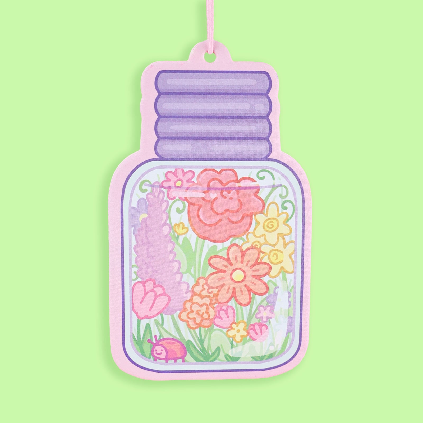 Decorative air freshener shaped like a jar with floral design on a green background