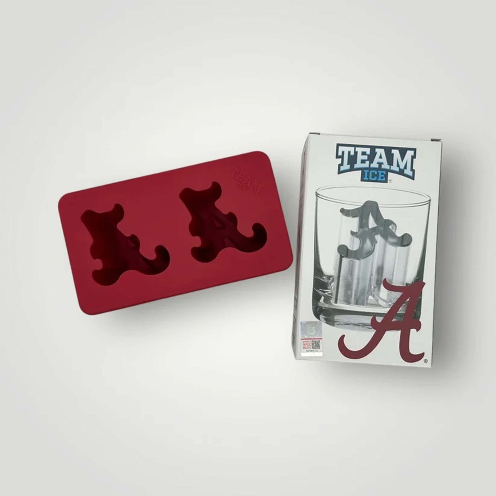 Crimson silicone Alabama ice mold with two scripted "A" cavities beside branded packaging.