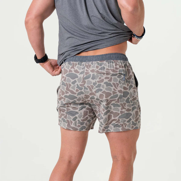 Back view of man wearing deer camo athletic shorts.