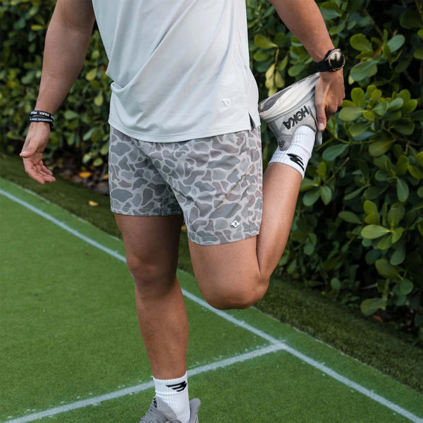 Man stretching on a turf field.
