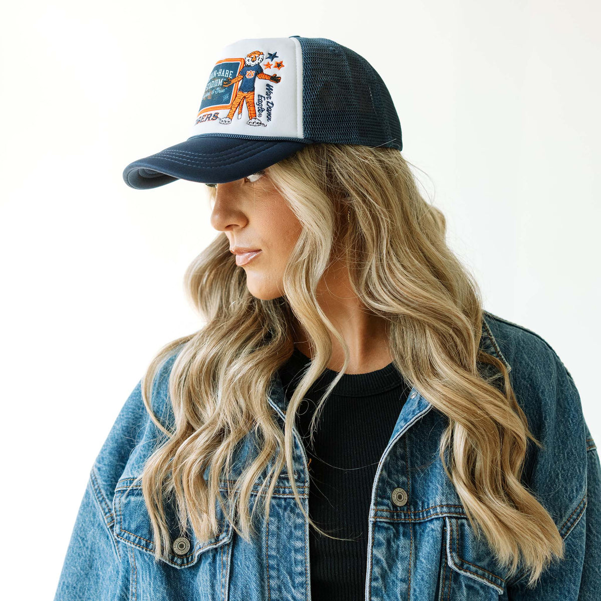 Auburn Tigers patch trucker hat with navy mesh back shown on model in a denim jacket