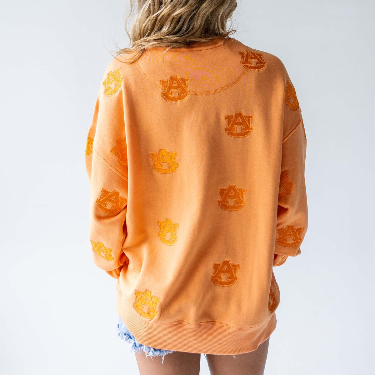 Back view of oversized orange sweatshirt with allover tonal Auburn University AU logo embroidery
