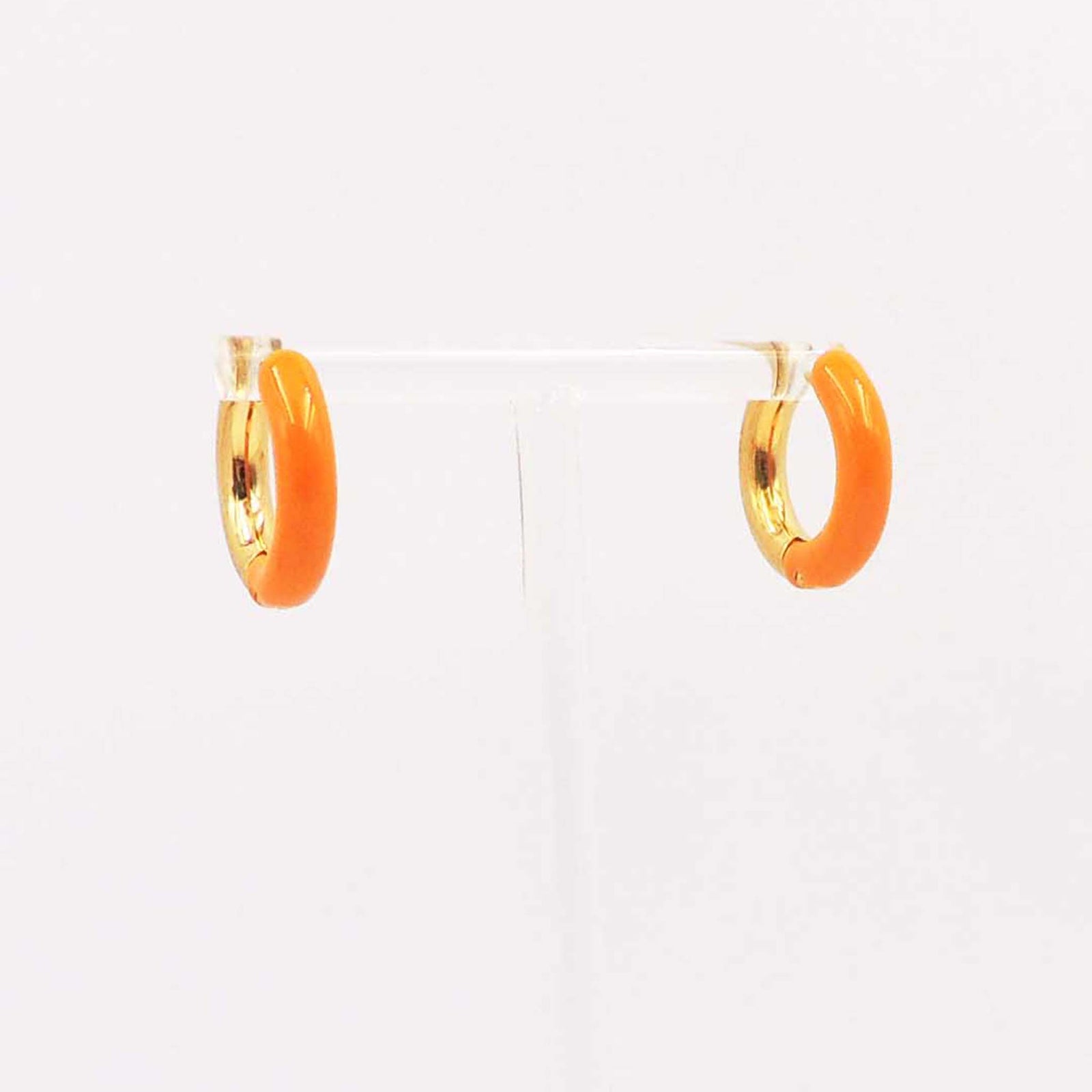 Pair of small orange enamel hoop earrings with gold-tone interior displayed on a clear stand.