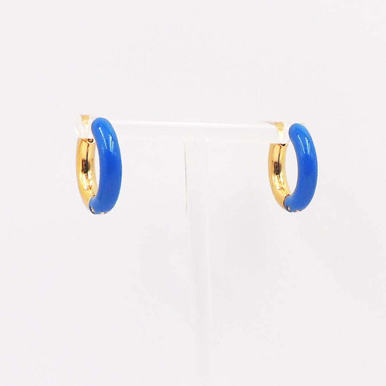 Pair of small gold-tone hoop earrings with glossy blue enamel accents displayed on a clear stand.