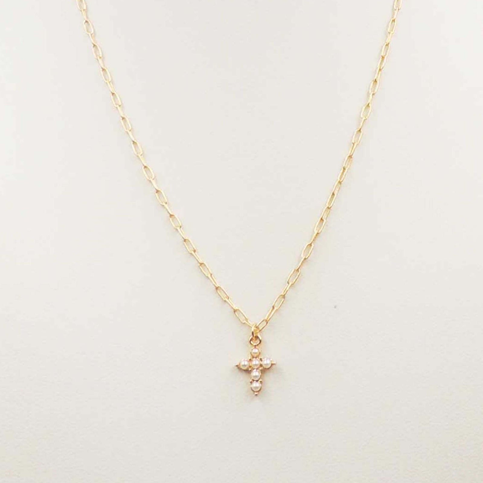 Gold chain necklace with cross pendant made of pearls.