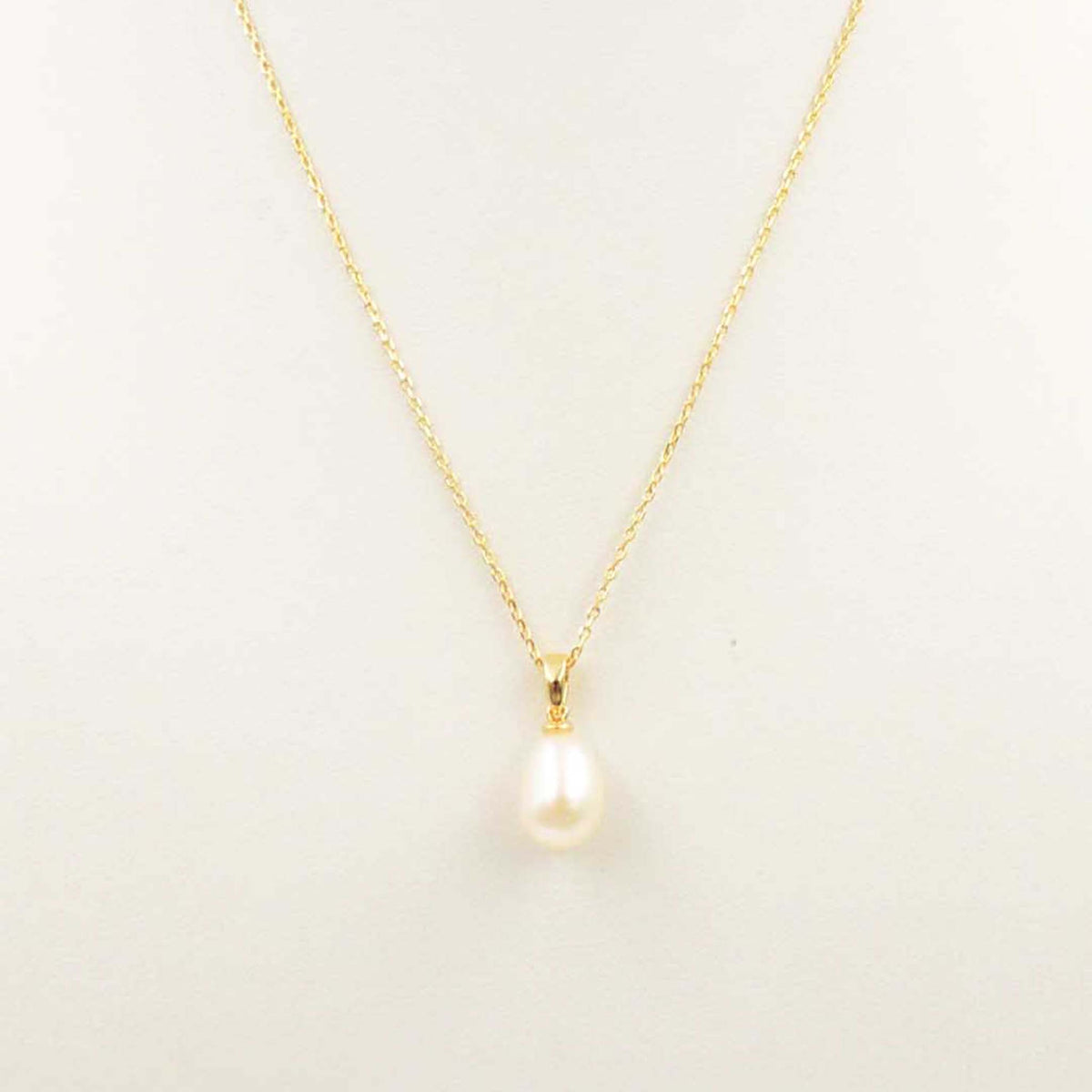 Gold necklace with a teardrop pearl pendant on a fine chain.