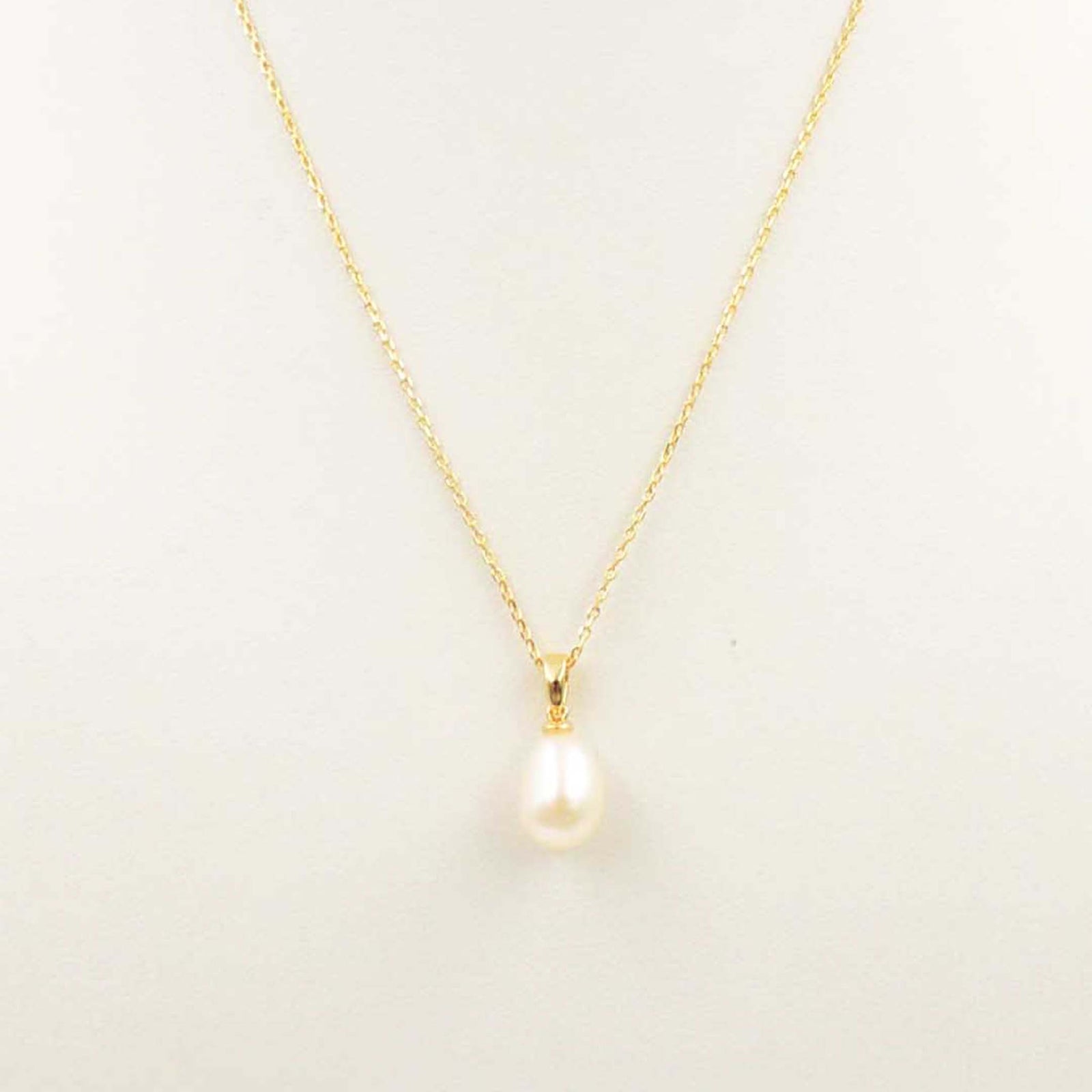 Gold necklace with a teardrop pearl pendant on a fine chain.