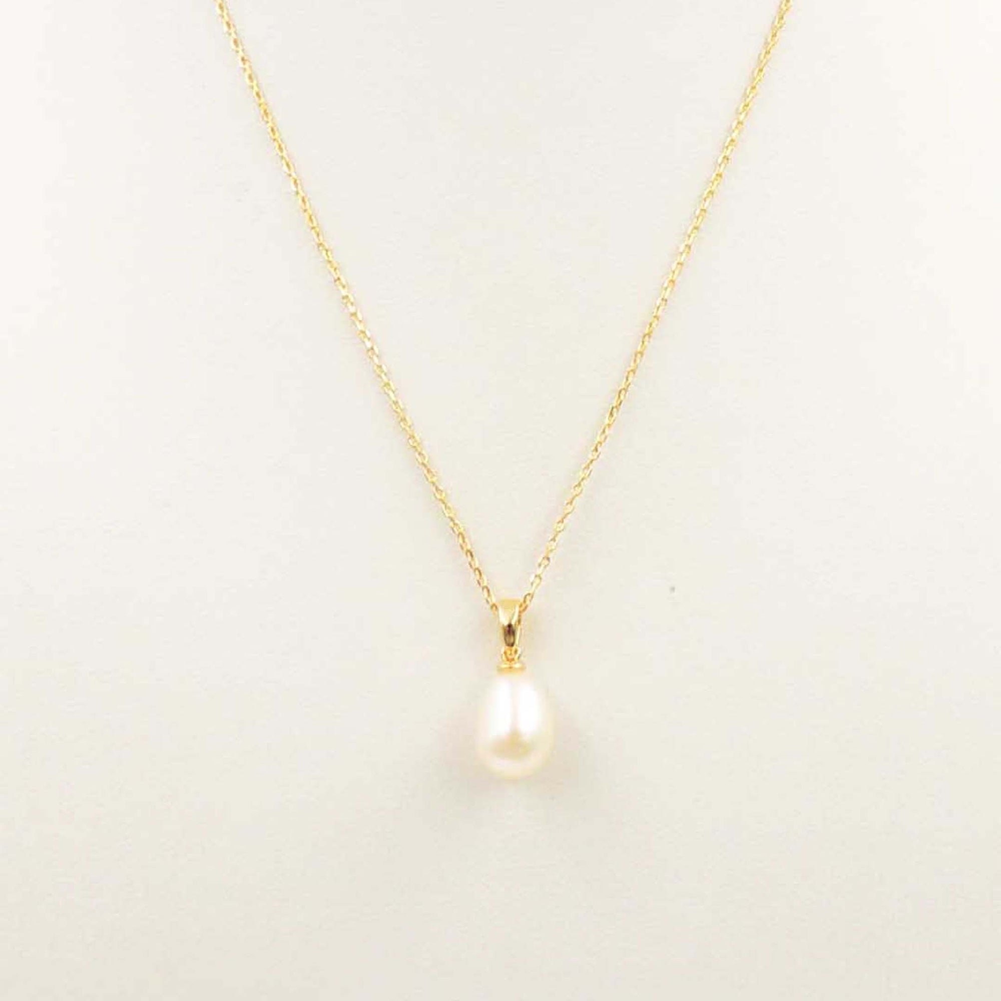 Gold necklace with a teardrop pearl pendant on a fine chain.