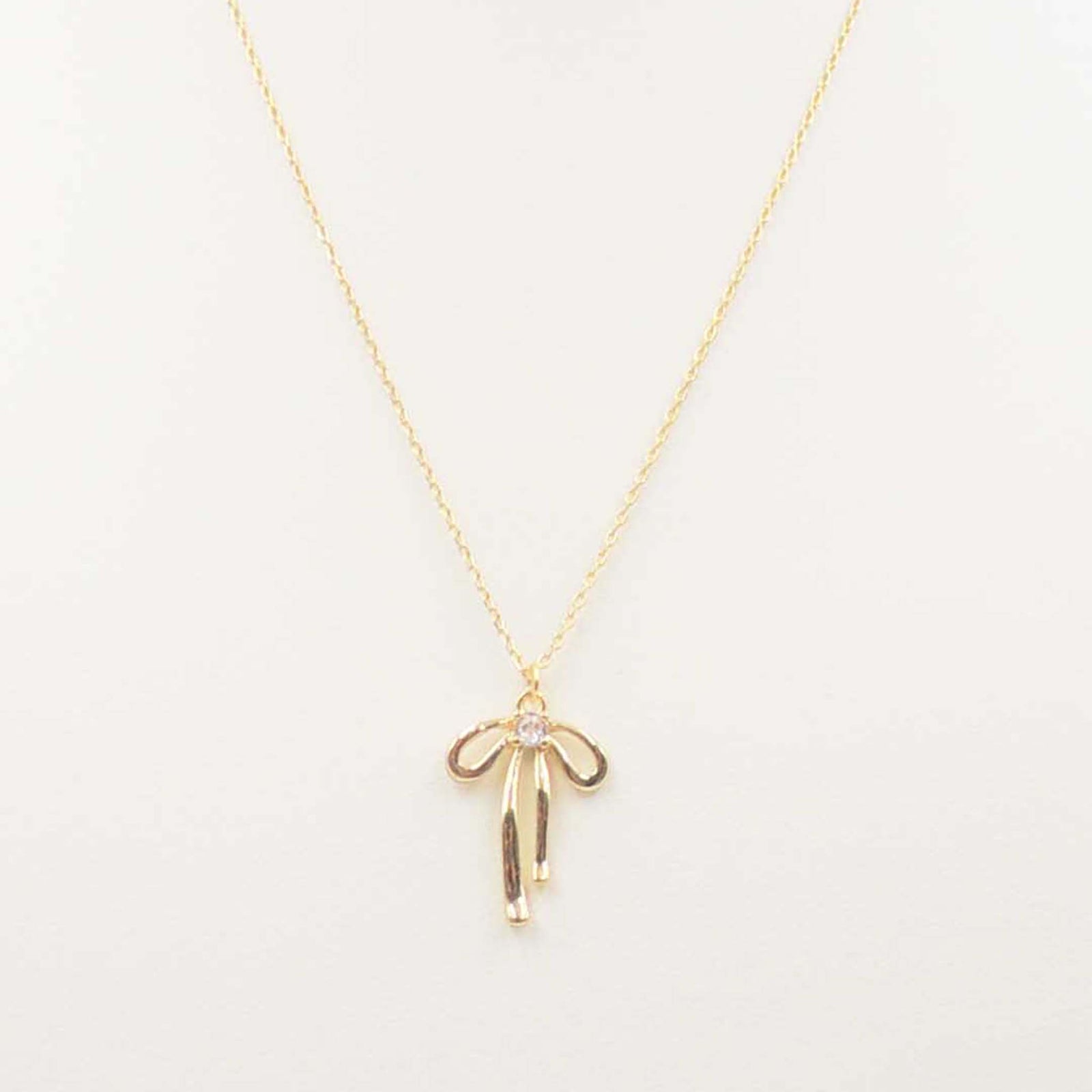 Gold chain necklace with open bow pendant and central crystal accent.