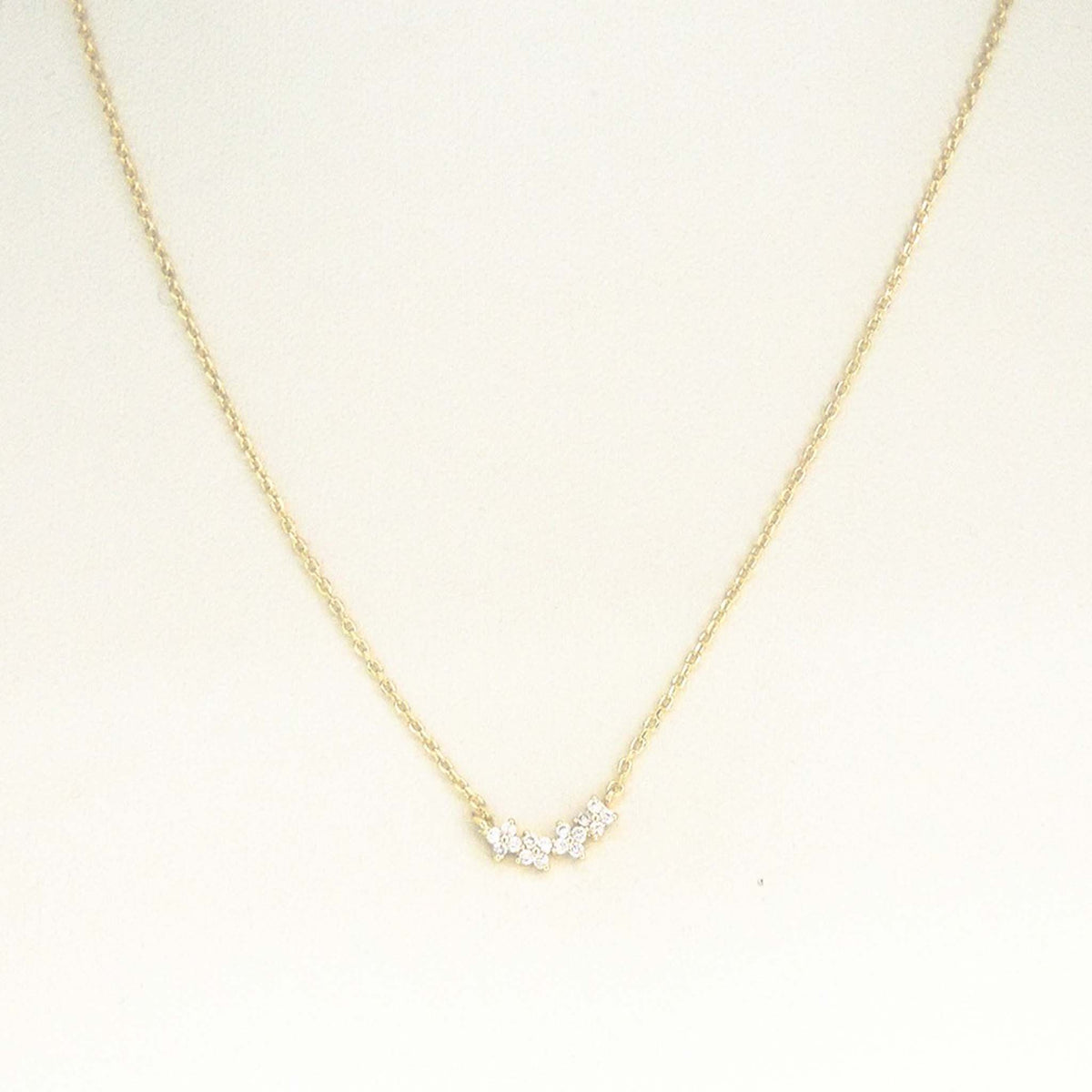 Gold dainty chain necklace with small crystal cluster pendant displayed on a white background.