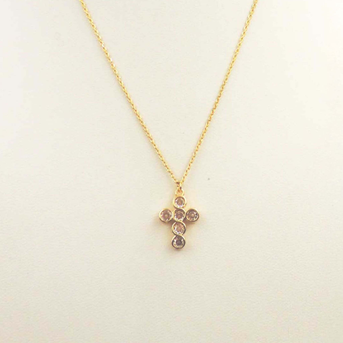 Gold necklace with a crystal-embellished cross pendant on a delicate chain.