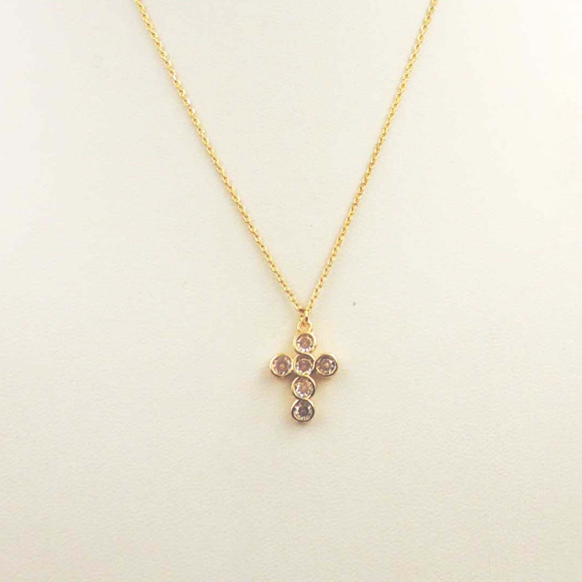 Gold necklace with a crystal-embellished cross pendant on a delicate chain.