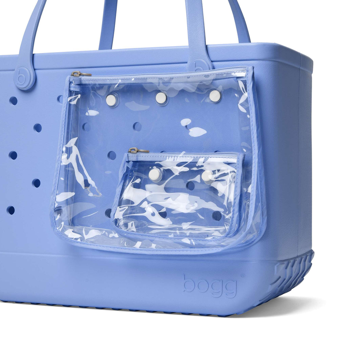 Periwinkle blue Bogg Bag with two zippered clear pouches attached to the side on a white background