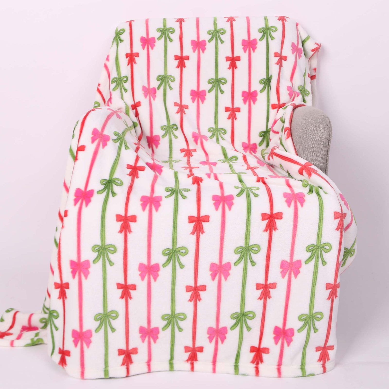 Holiday bows blanket laid out on a chair.