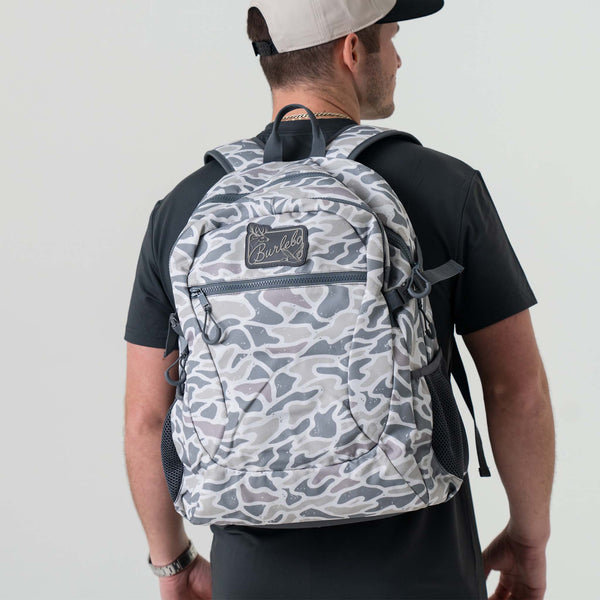 Burlebo backpack in white camo worn by a person facing away, showing the backpack’s size, shape, and shoulder strap fit from the back view.