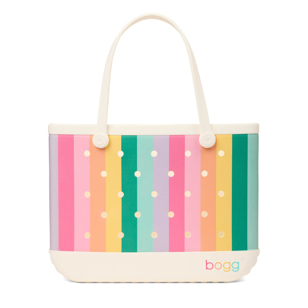 Bogg Bag pastel rainbow striped tote with cream handles, cream base, and multicolor Bogg logo on front.