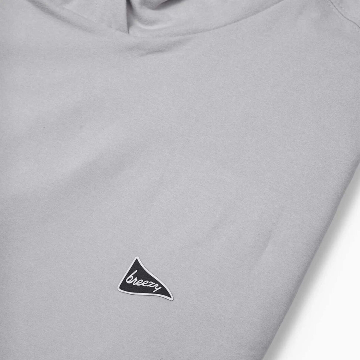 Angled view of folded Breezy grey hoodie showing hood and chest logo.